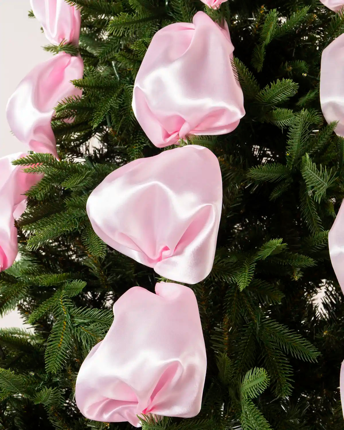 Close-up of glossy pink satin ribbon fabric gathered into soft folds