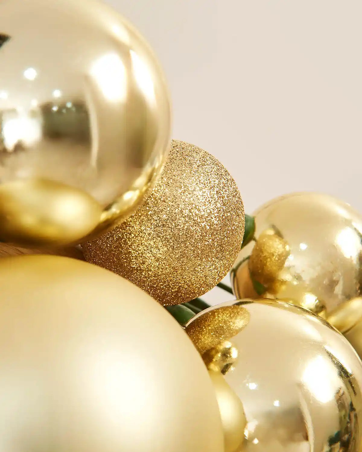 Close-up of gold glitter and shiny baubles on a light background