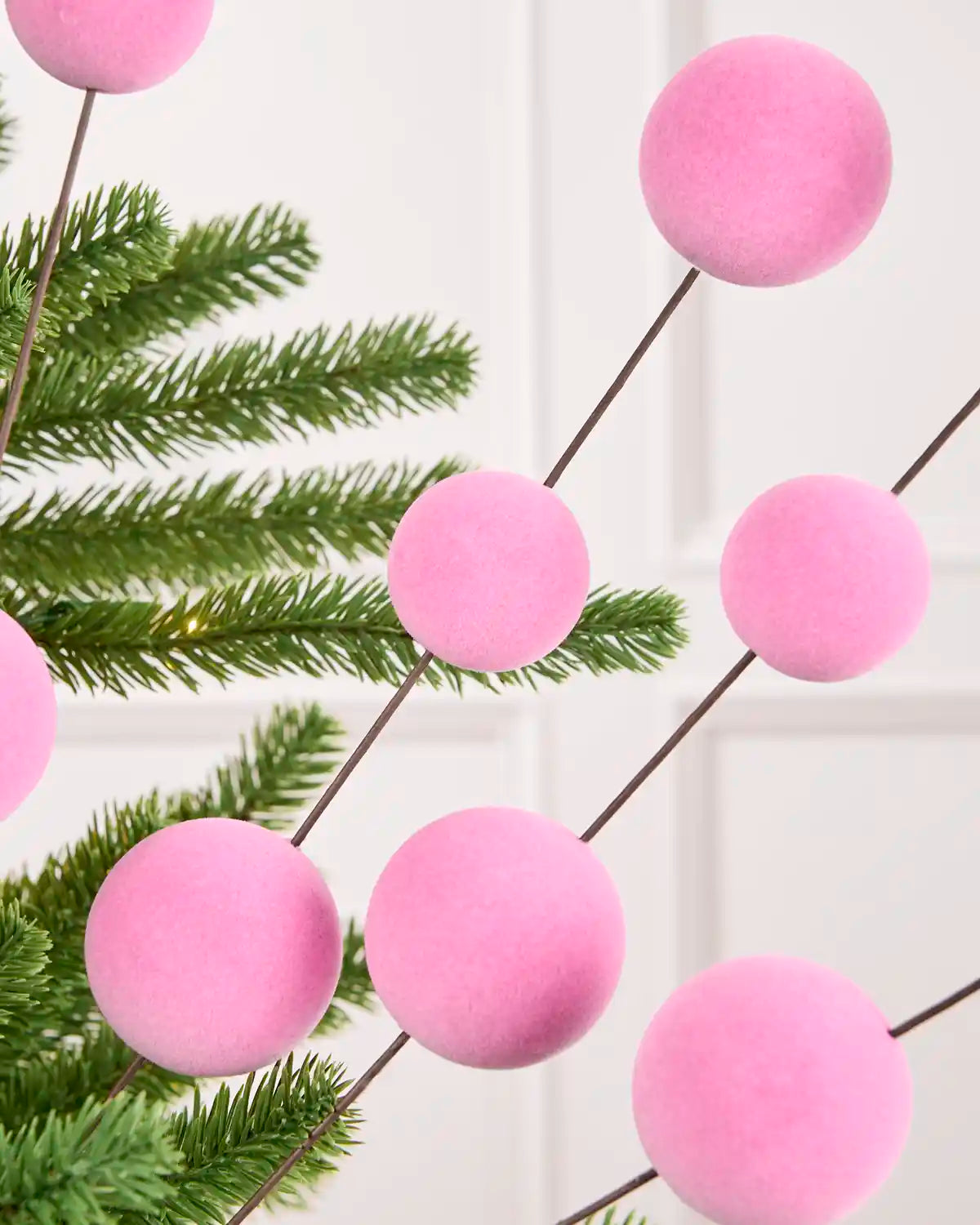 Close-up of pink Velvet Bauble Picks on Christmas tree branches