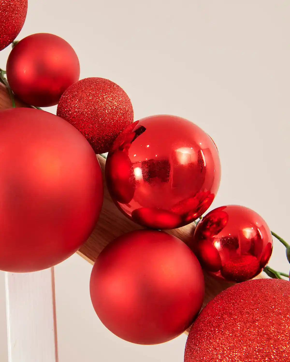 Close-up of red Christmas bauble garland on a plain background