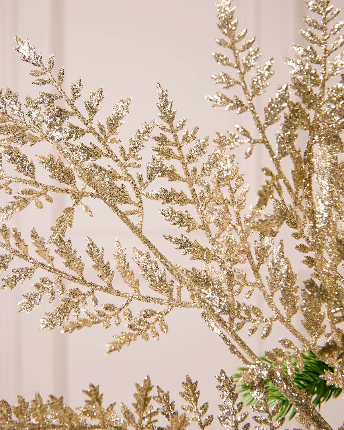 Close-up of shimmering gold glitter foliage with delicate leaf-shaped branches