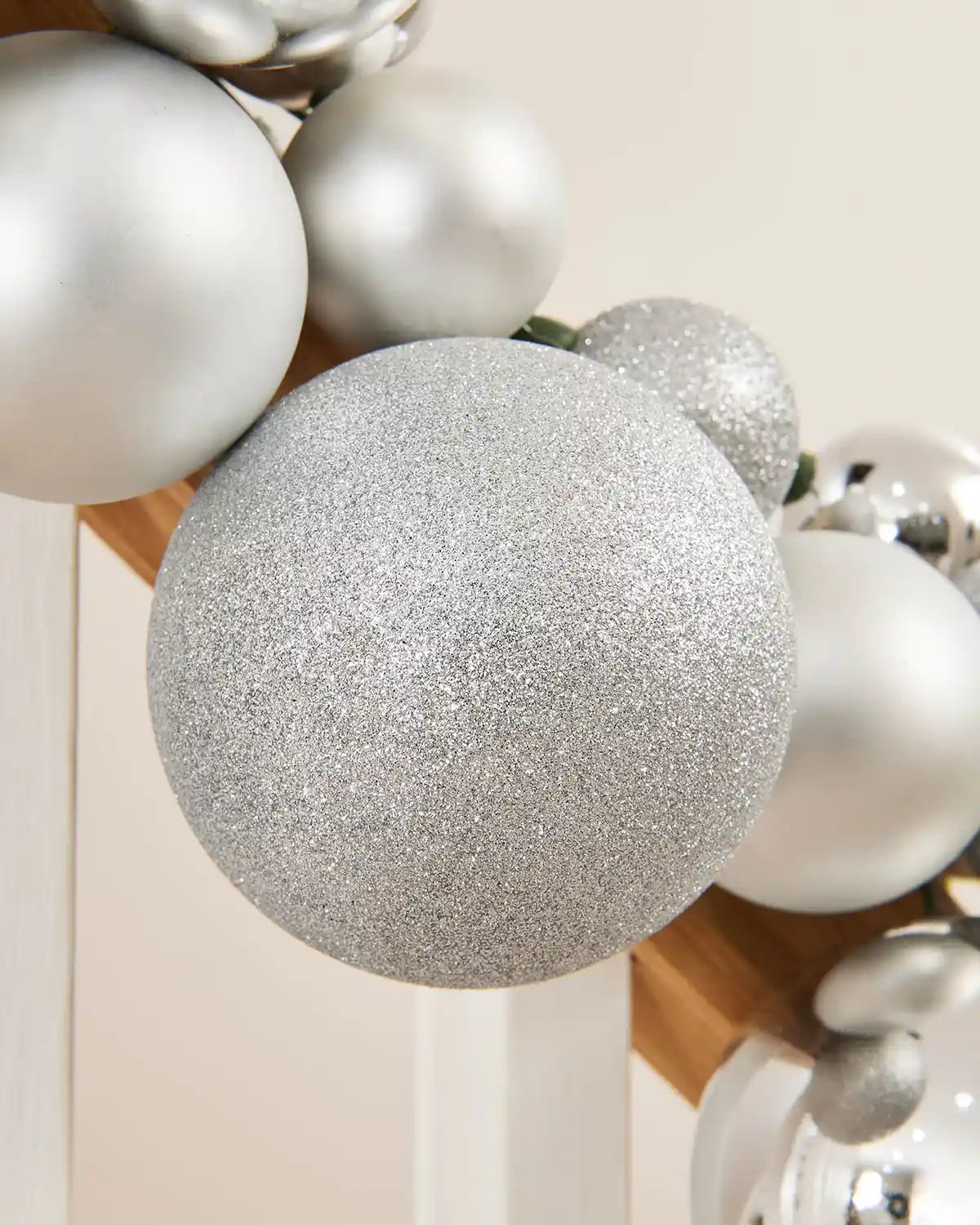 Close-up of silver glitter and shiny baubles on a light background
