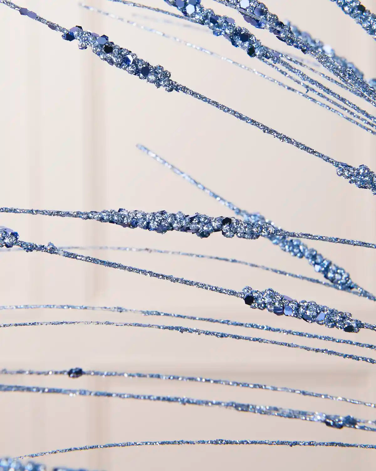 Close-up of the Ice Blue Glitter Wispy Spray, showing textured glitter-covered stems and clustered decorative details
