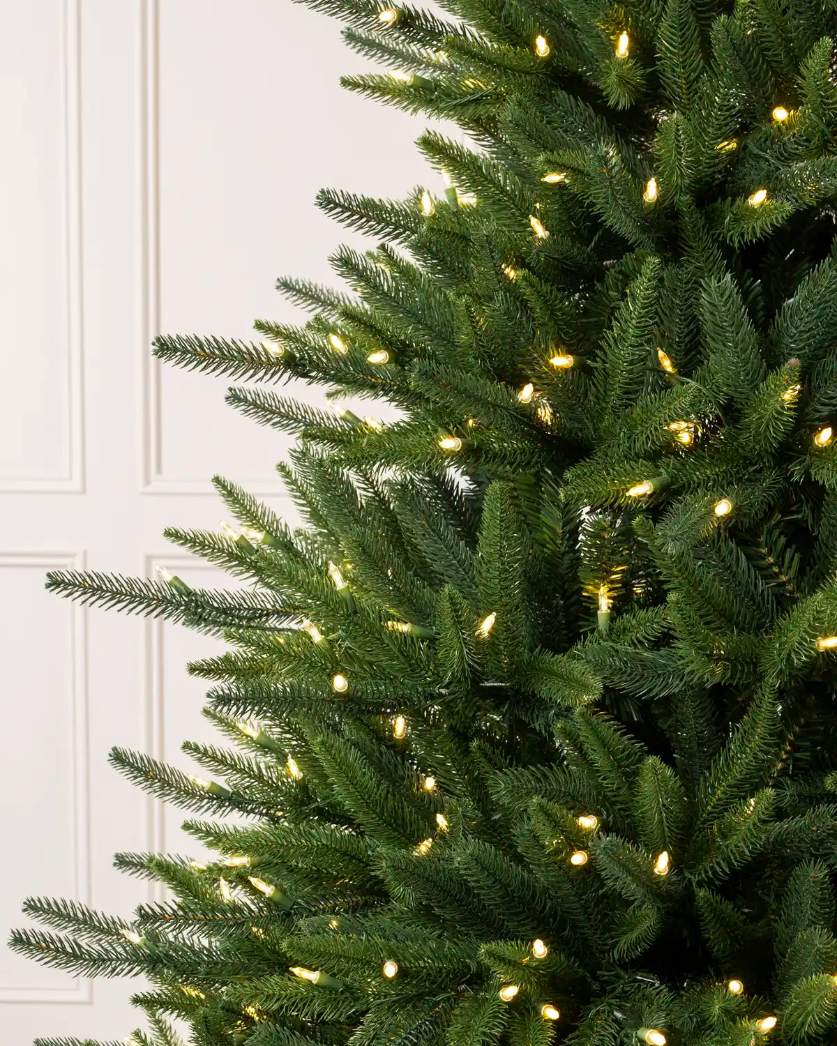 Close-up of the Pre-Lit Hawthorn Spruce Christmas Tree’s realistic green branches and warm white lights