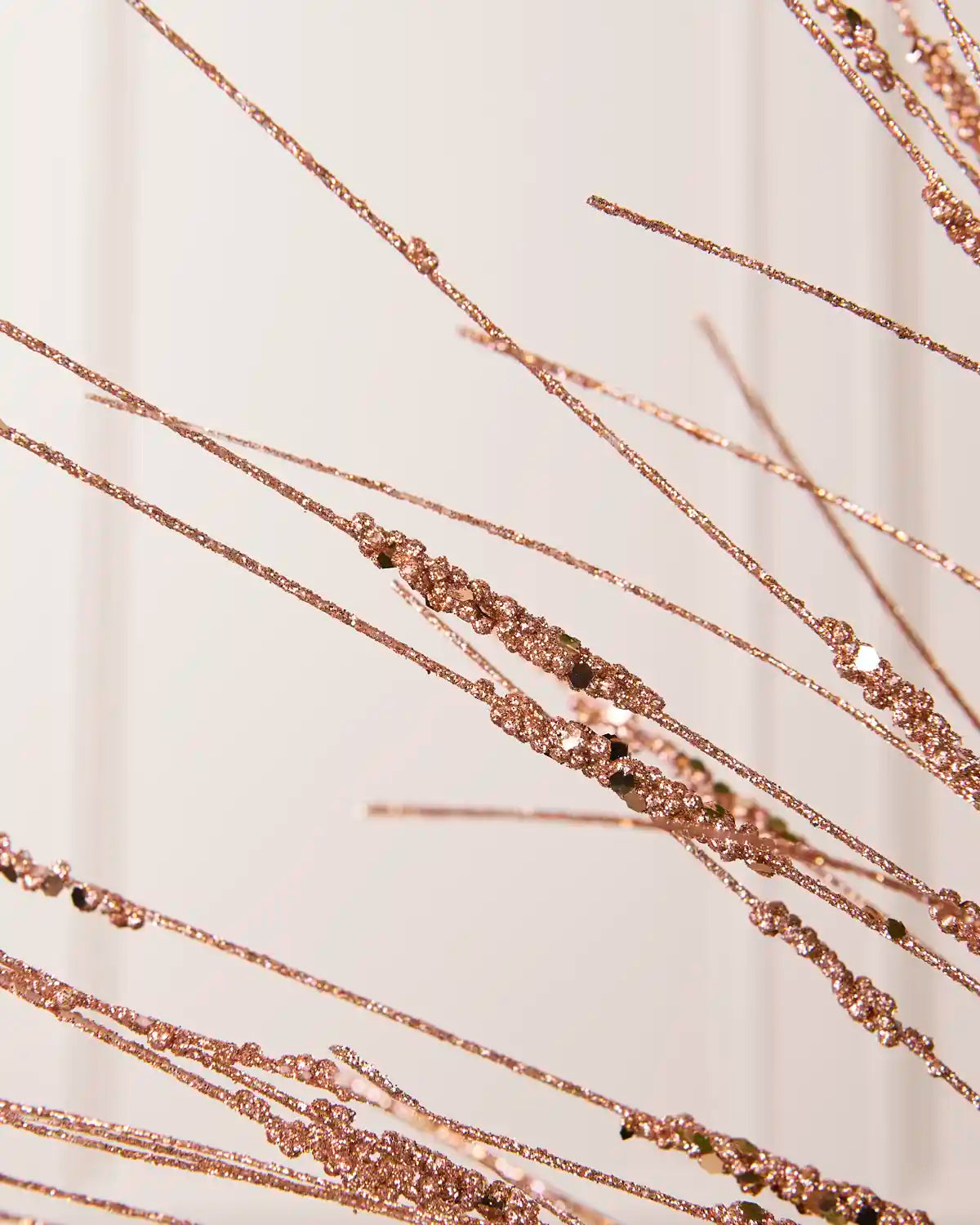 Close-up of the Rose Gold Glitter Wispy Spray, showing textured glitter-covered stems and clustered decorative details
