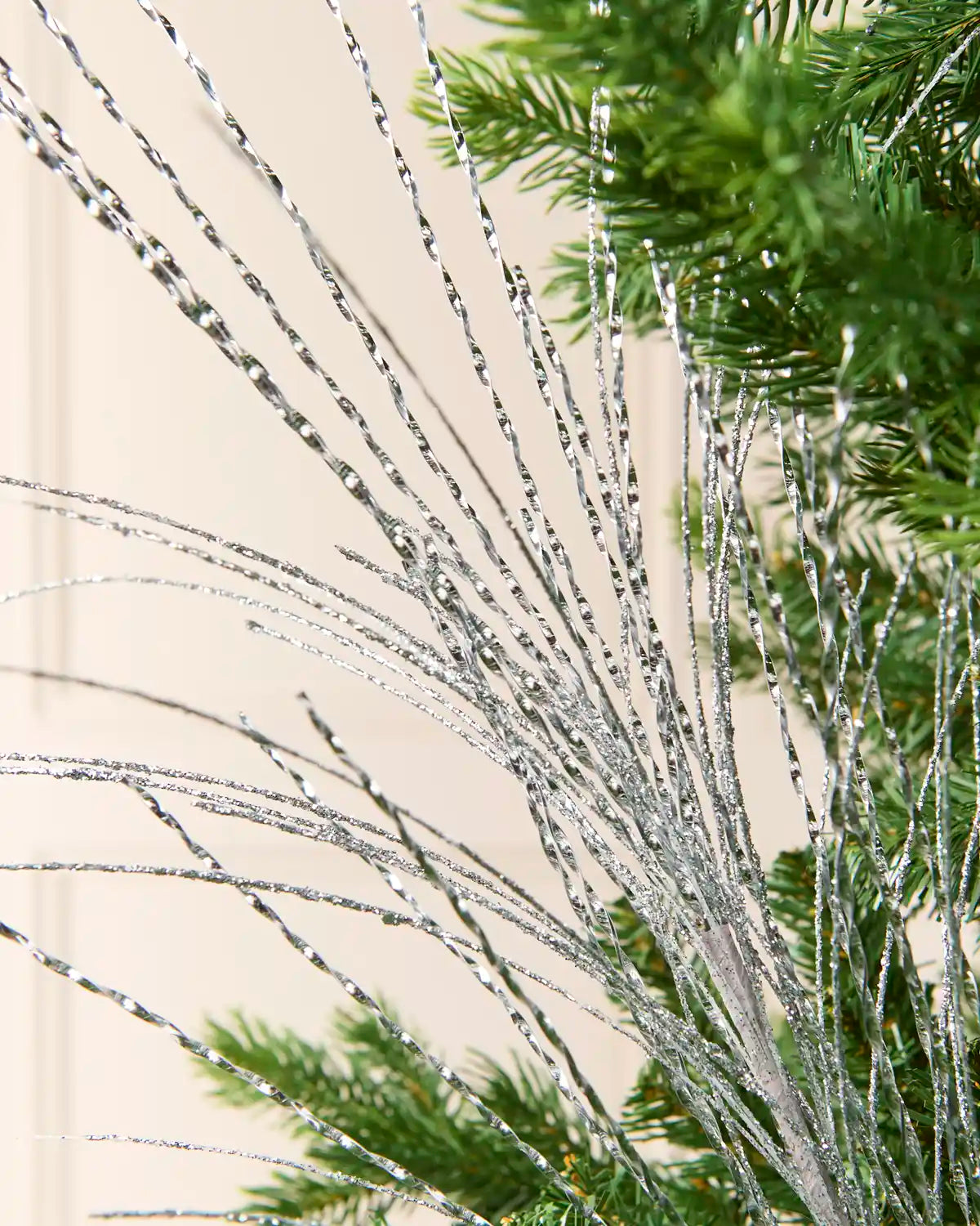Close-up of the Silver Glitter Fountain Christmas Tree Spray, showing its twisted metallic strands
