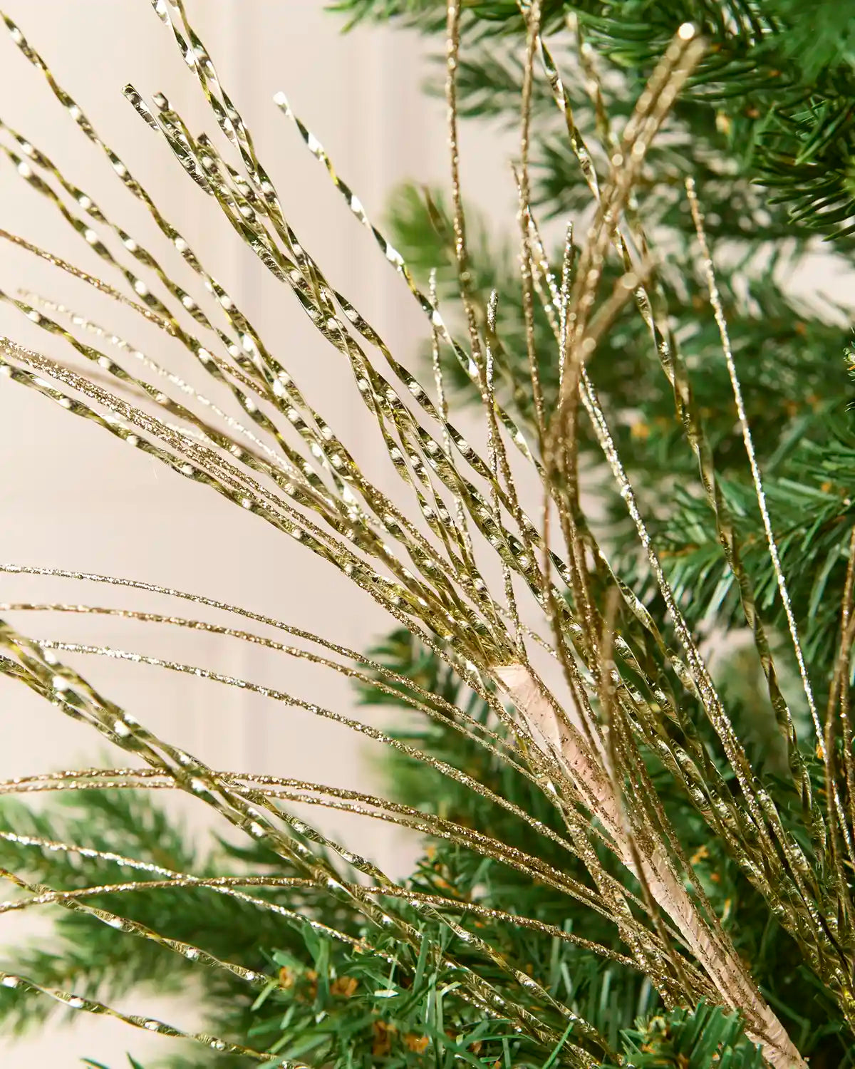 Close-up of the gold Glitter Fountain Christmas Tree Spray, showing its twisted metallic strands