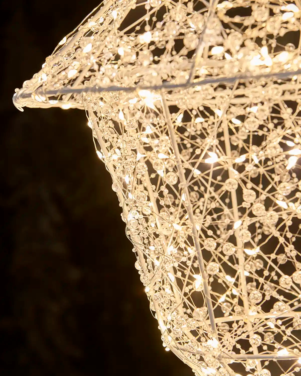 Close-up of the intricate beaded wire detailing and warm white lights on the lantern section