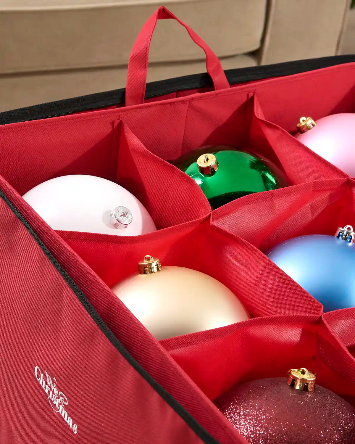 Close-up of the red storage bag’s individual fabric compartments protecting Christmas baubles, showing the sturdy stitched dividers and carry handle