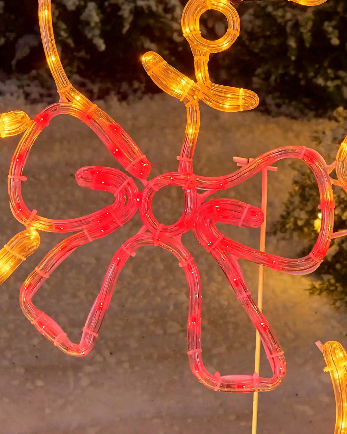 Close-up of the teddy bear’s large red illuminated bow, showing the rope-light construction and supporting frame