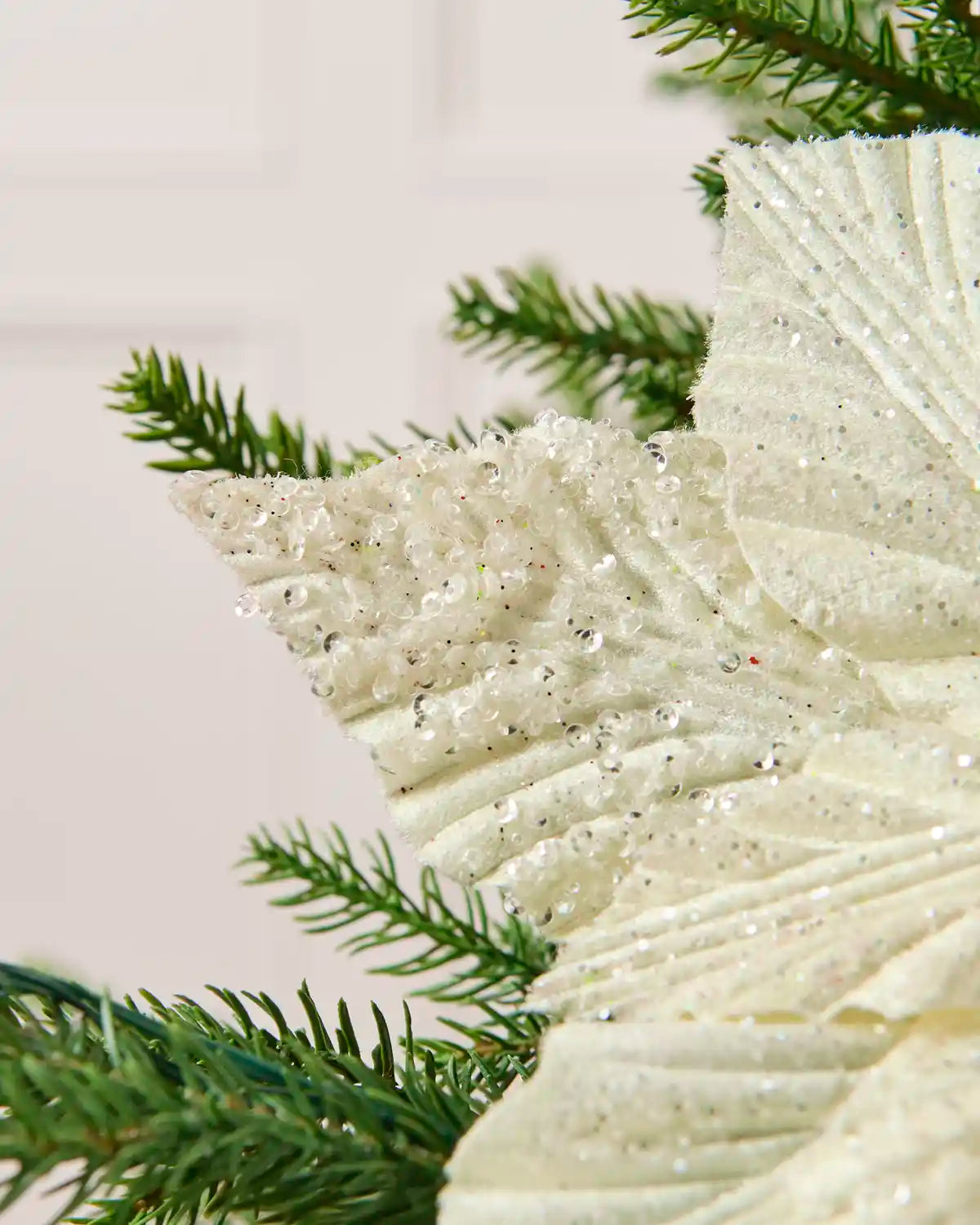 Close-up of the textured cream poinsettia petal covered in glitter and sequins