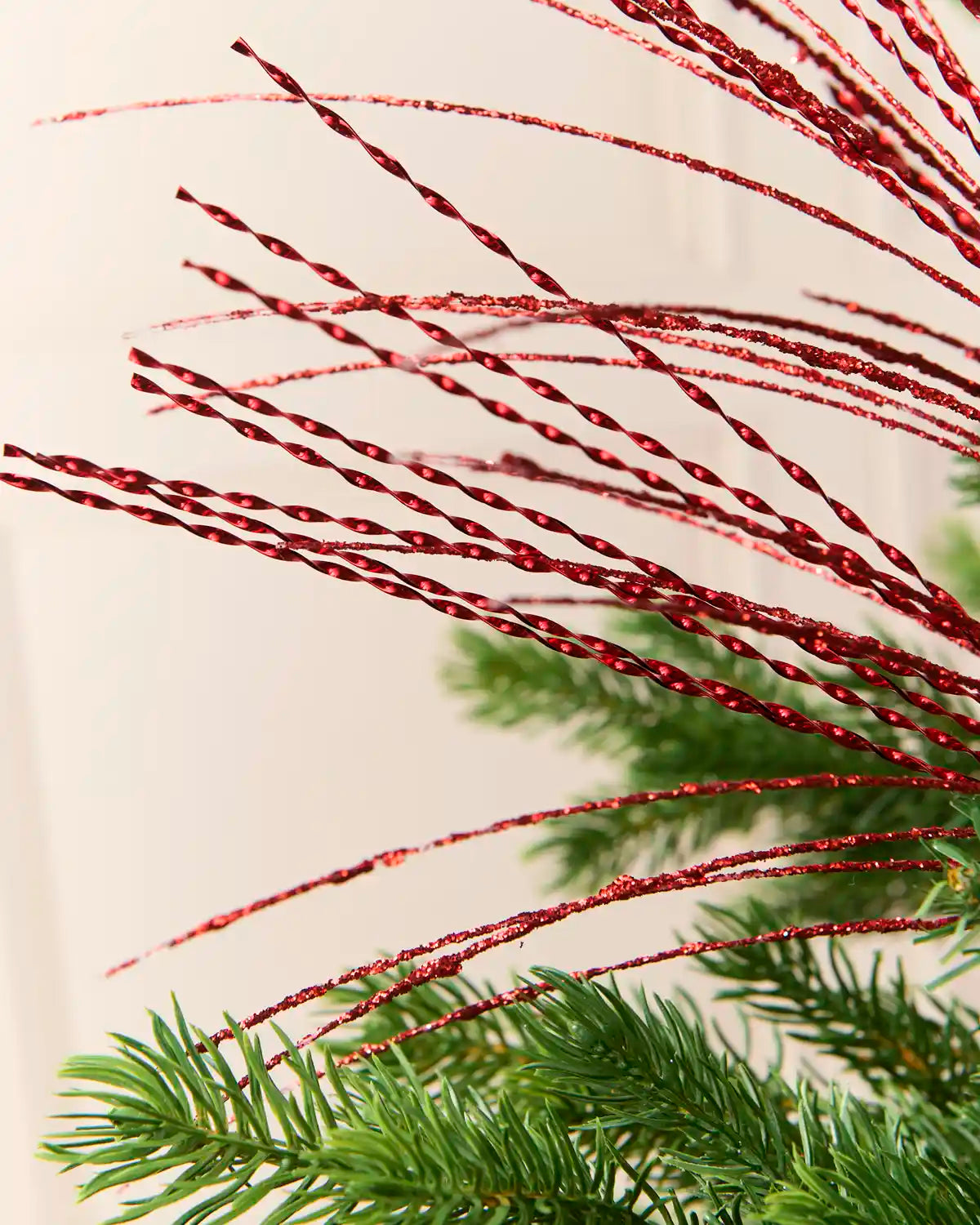 Close-up of thin red glitter fountain strands extending outward 