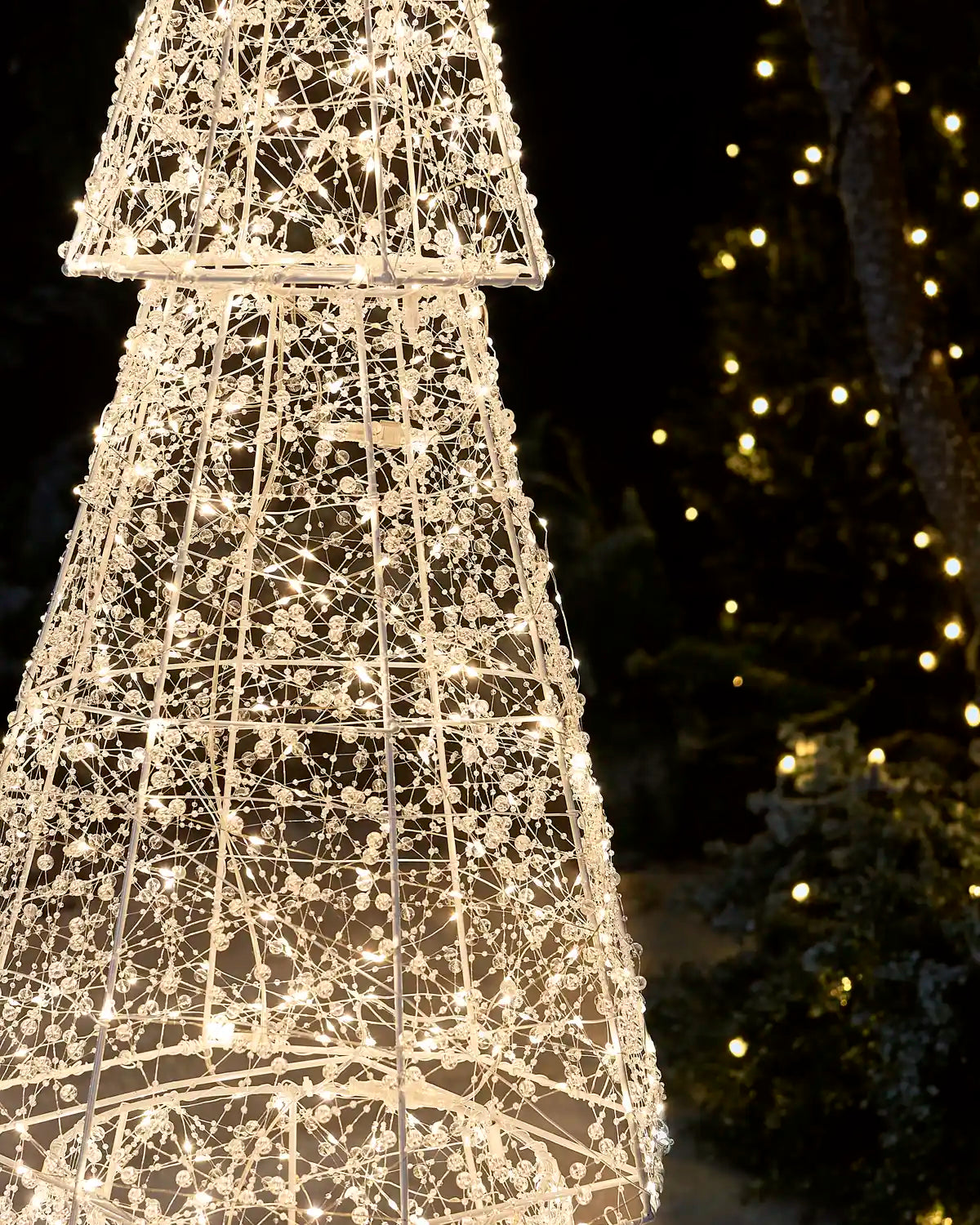 Close-up of warm white lights and clear beads wrapped around the wire frame of the Pre-Lit Twinkling Beaded Christmas Tree