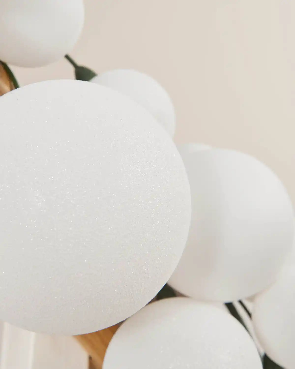 Close-up of white glitter and shiny baubles on a light background
