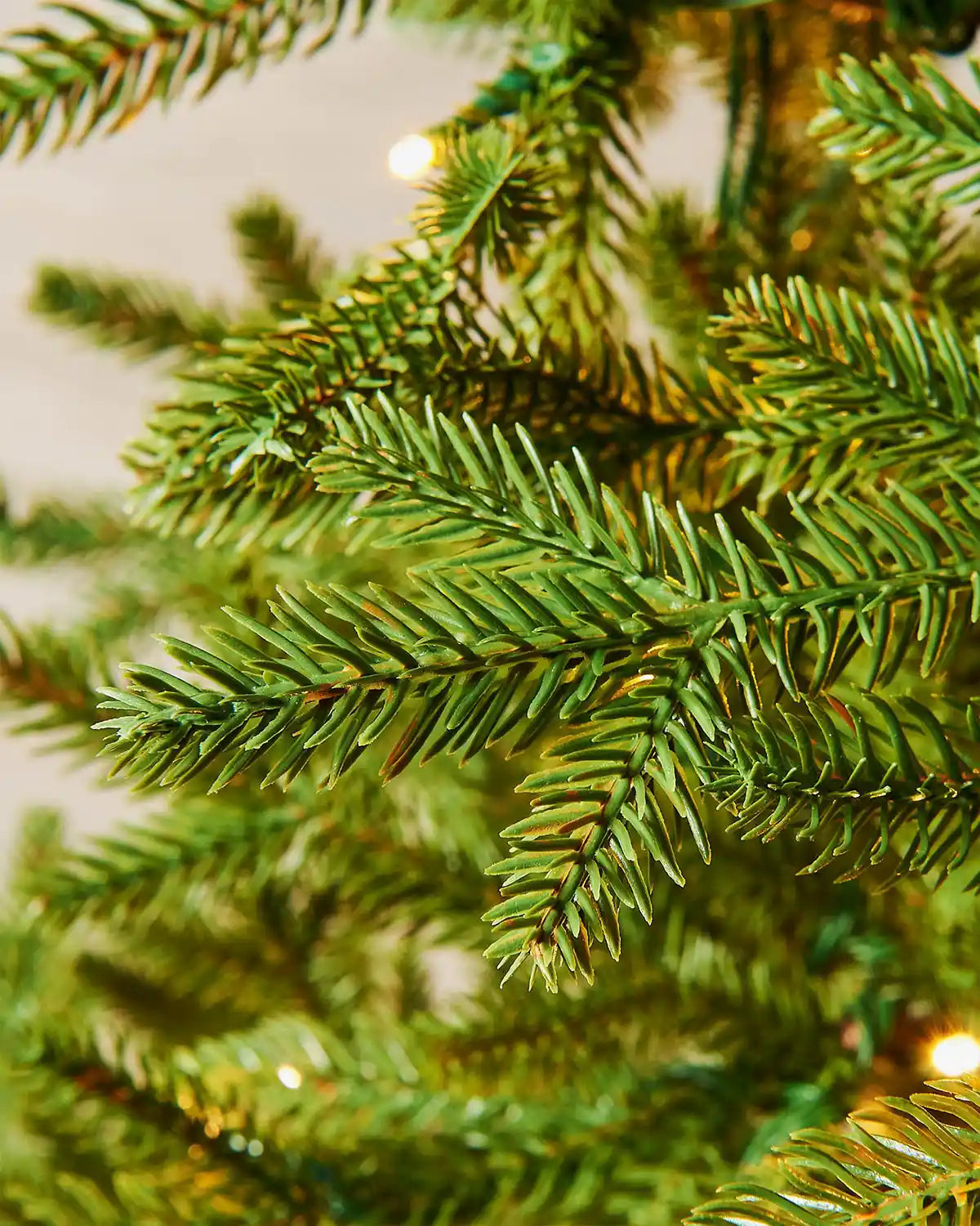 Close-up of 6ft pre-lit nordic pine Christmas tree branches on warm light setting