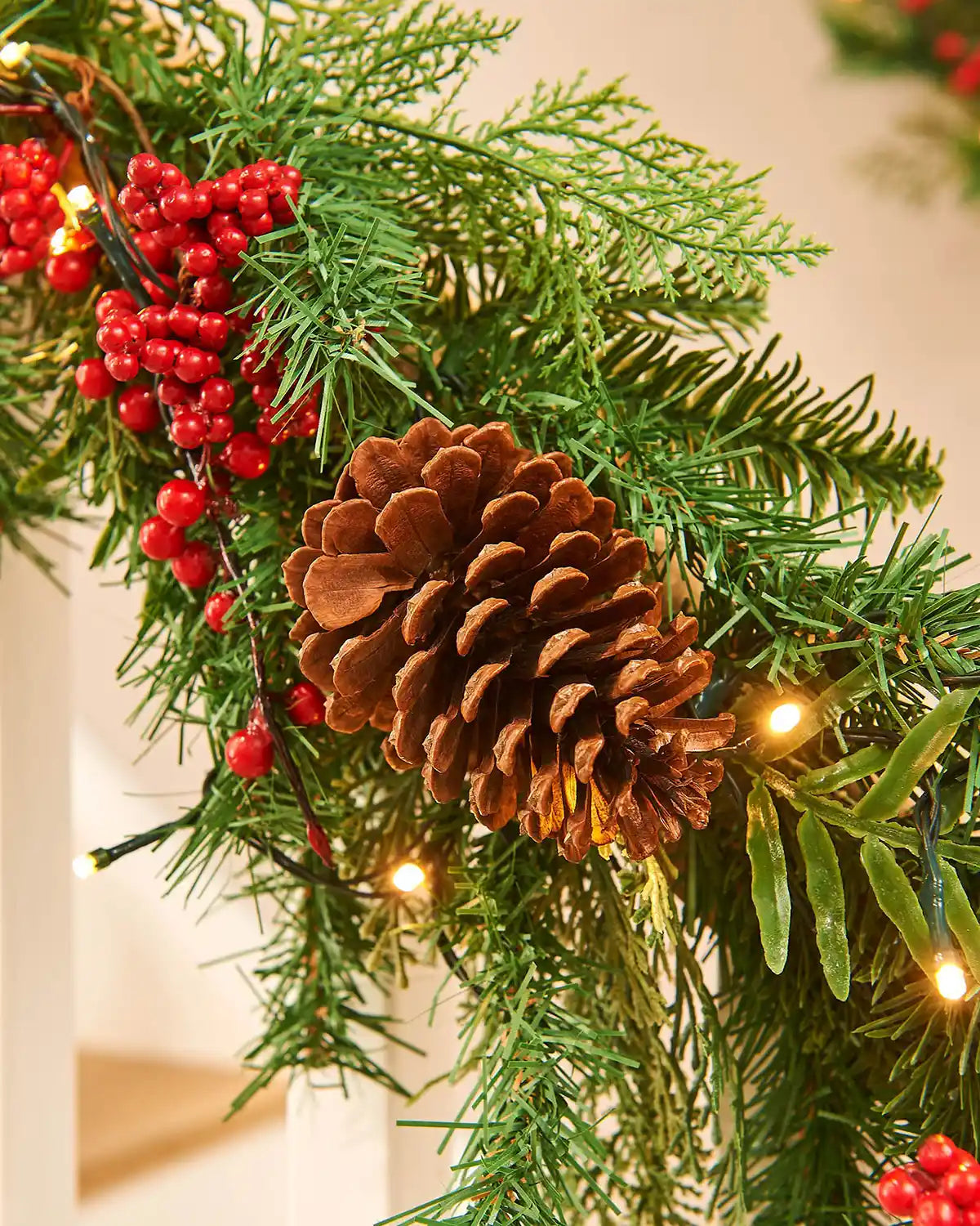 Close up Christmas garland with pine cones and red berries on a neutral background