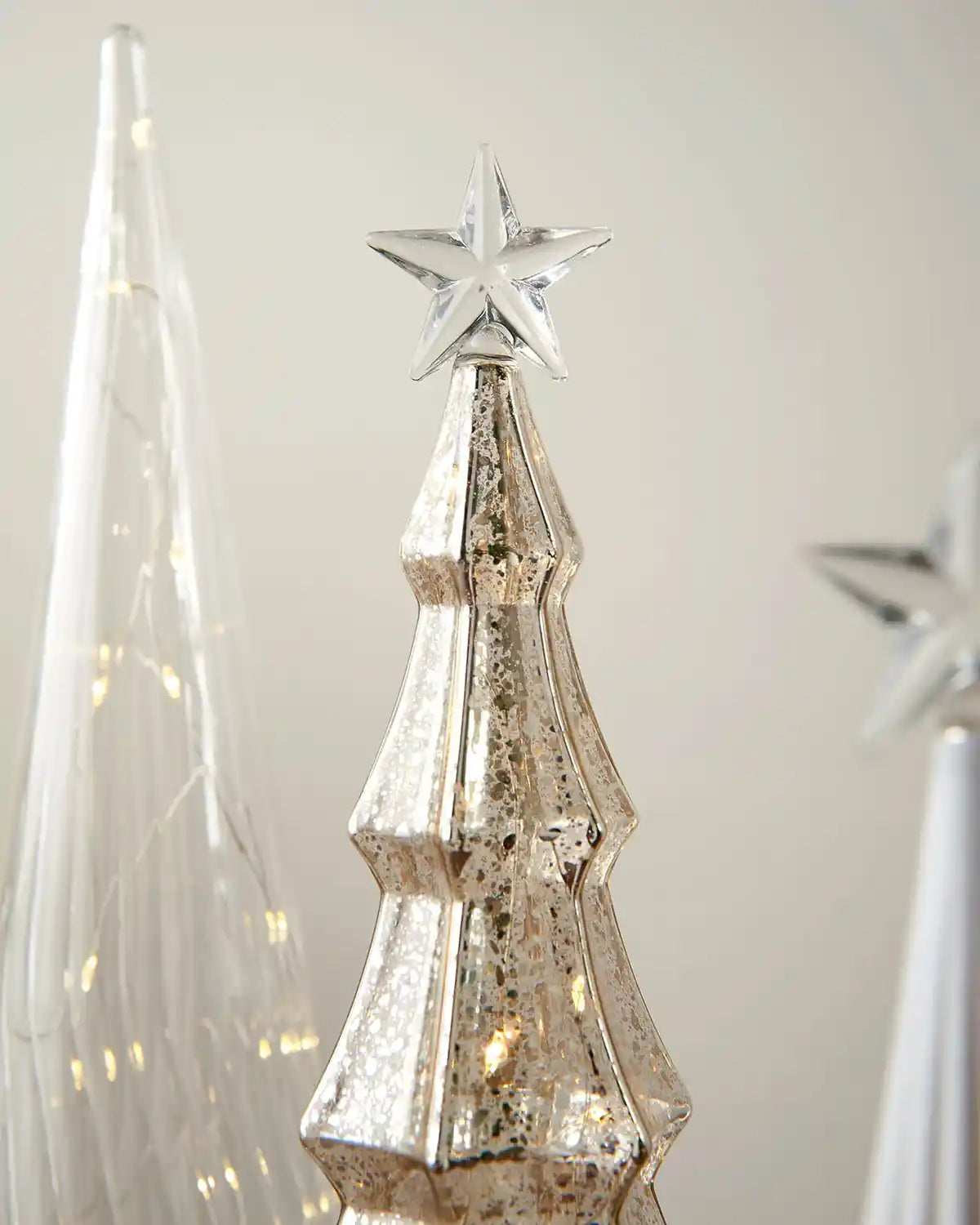 Close up Decorative Christmas tree with star topper on a neutral background