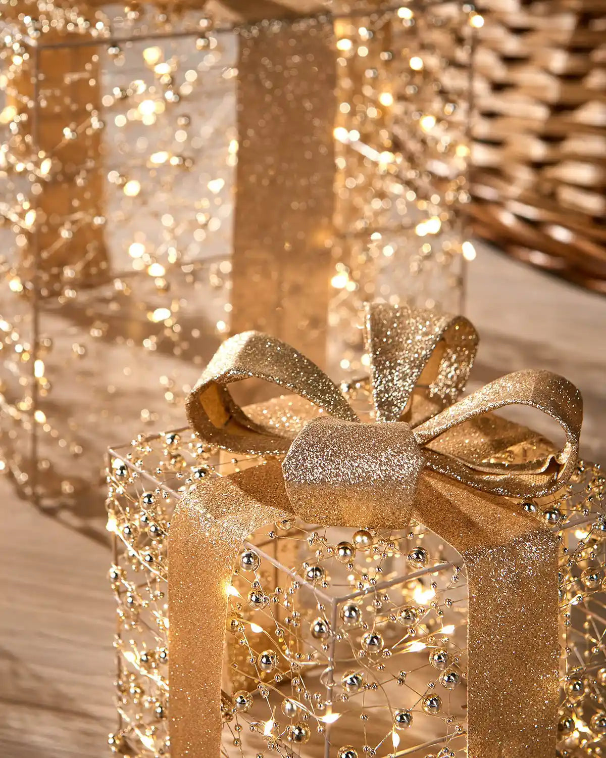 Close up Decorative gold and copper gift boxes with LED lights on a wooden floor blurry background