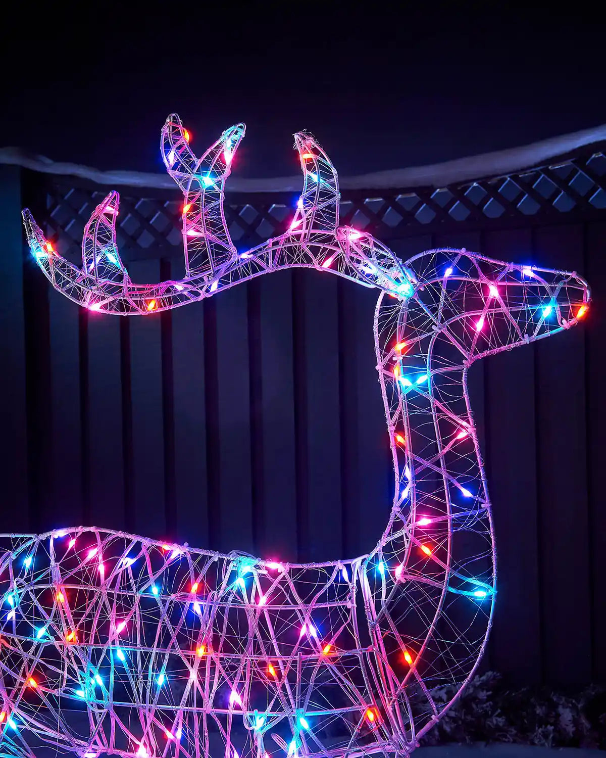 Close up Decorative reindeer figure with multicoloured lights against a dark background