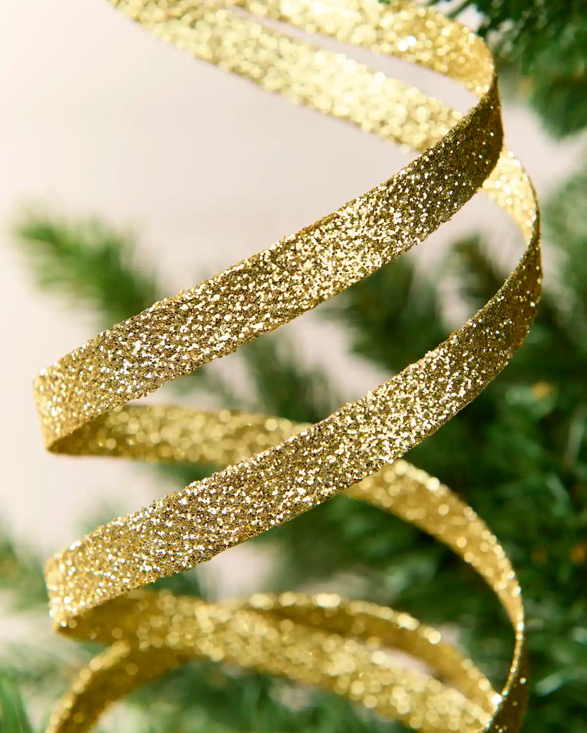 Close up Gold Glitter Spiral Swirl Pick with green and cream blurred background