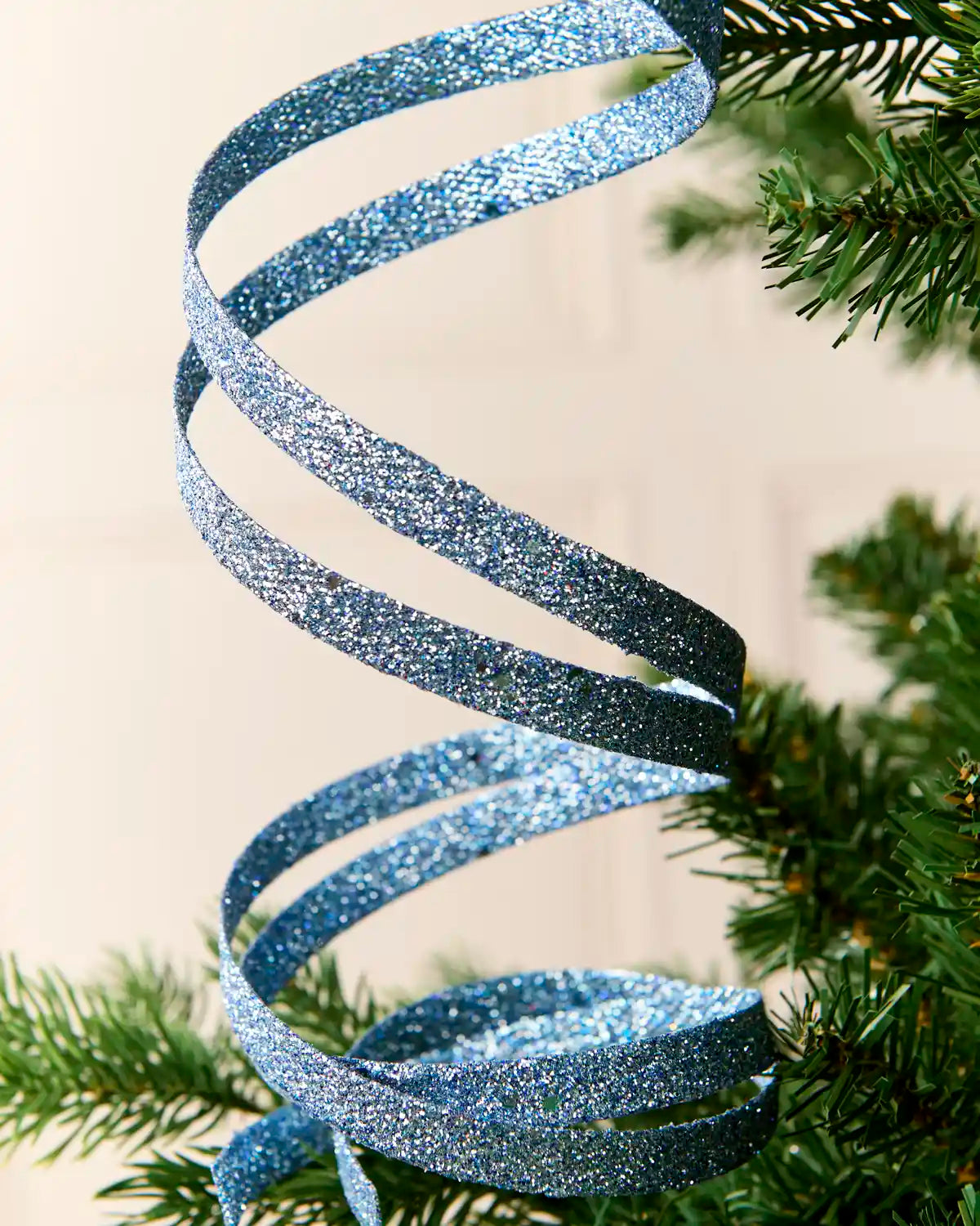 Close up Ice Blue Glitter Spiral Swirl Pick hanging from Christmas tree

