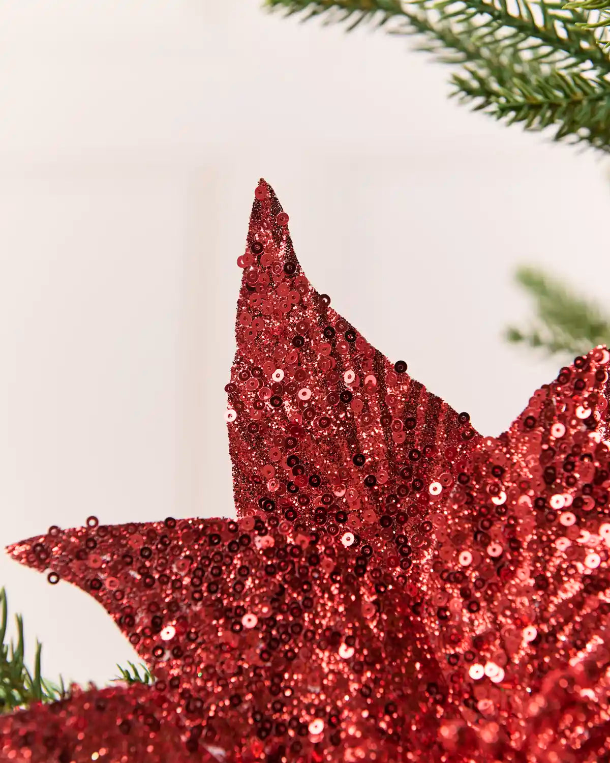 Close up Red Sequin Artificial Poinsettia petal showing sequin detailing 