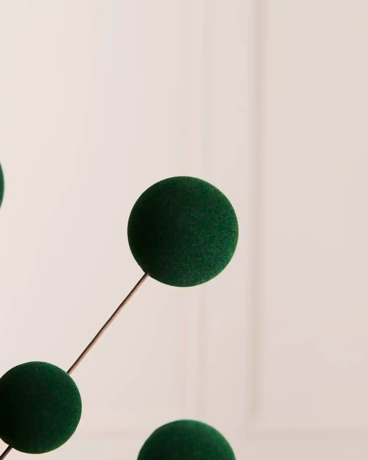 Close up Sage green velvet bauble pick against a light background 