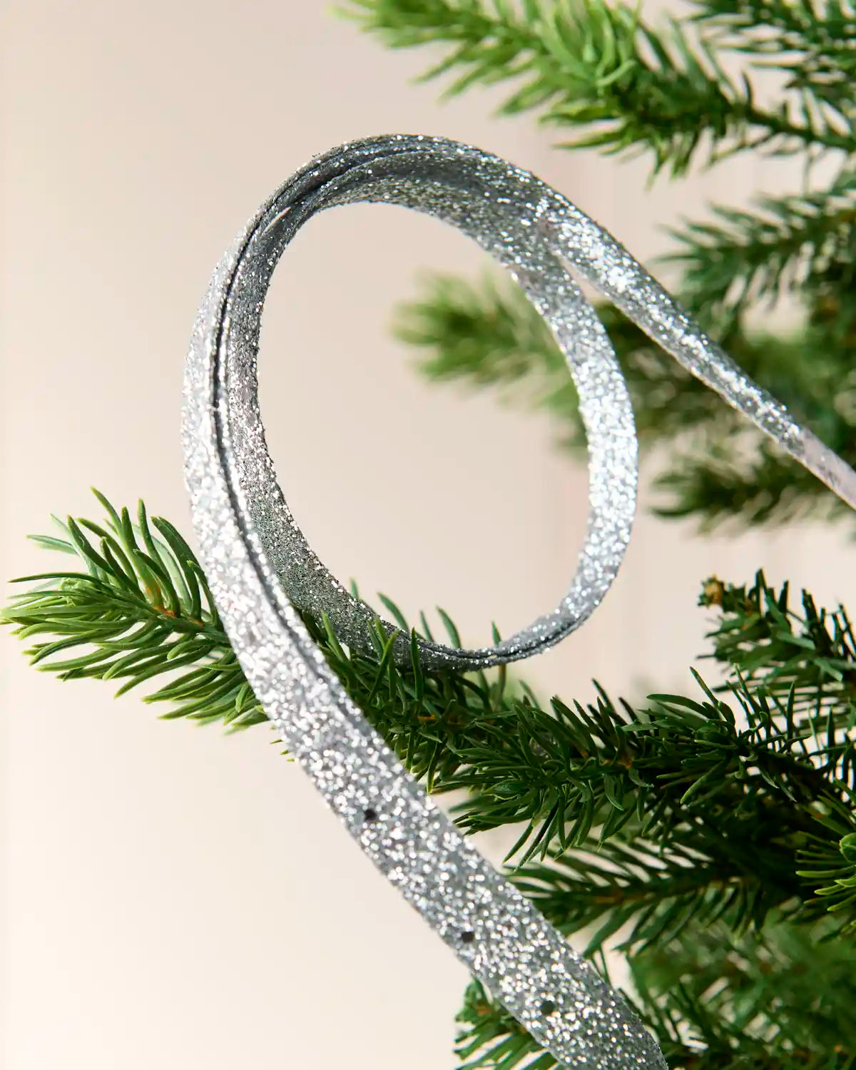 Close up Silver Glitter Spiral Swirl Pick hanging from Christmas tree
