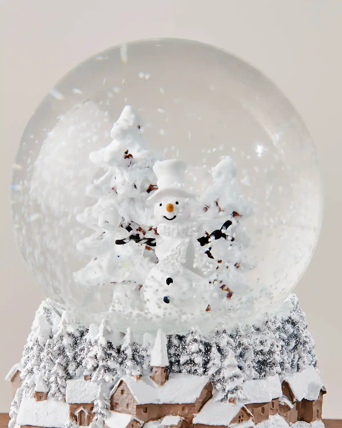Centralised close-up of snowman snow globe in front of white background