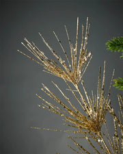 Close-up of gold glitter firework spray highlighting sequins in front of grey background