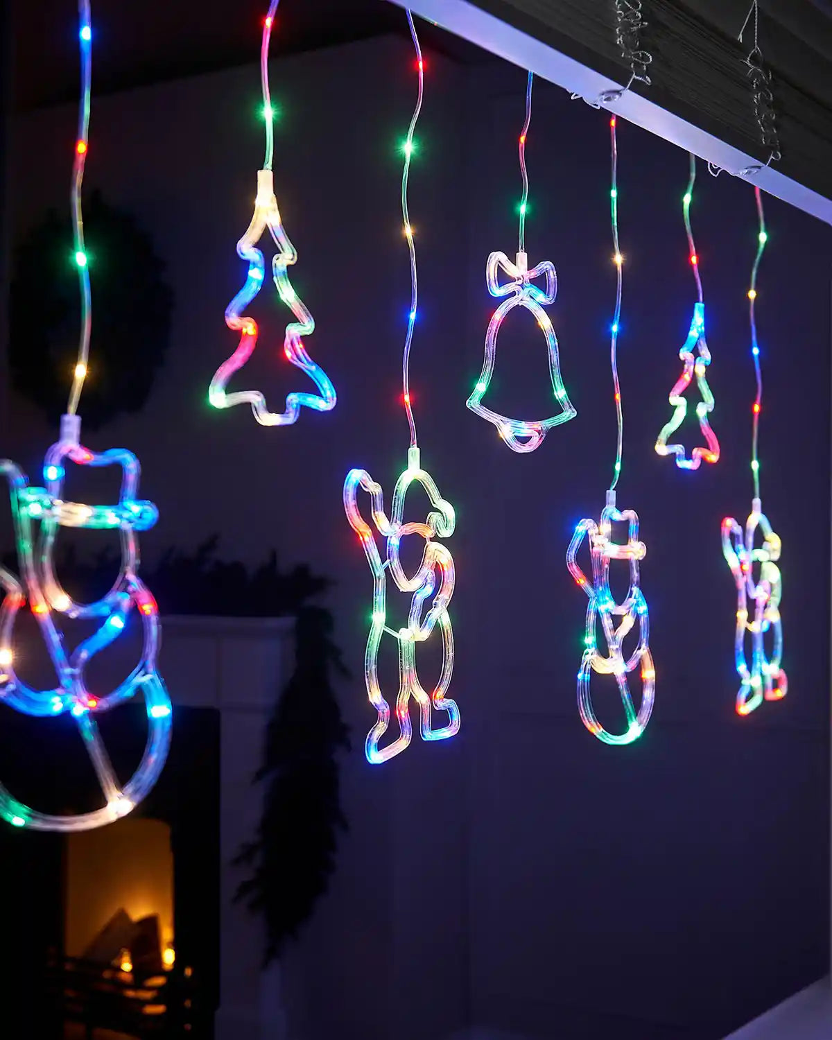 Close up of Christmas Character Curtain Light, 2.1 m in a window with a fire place in background