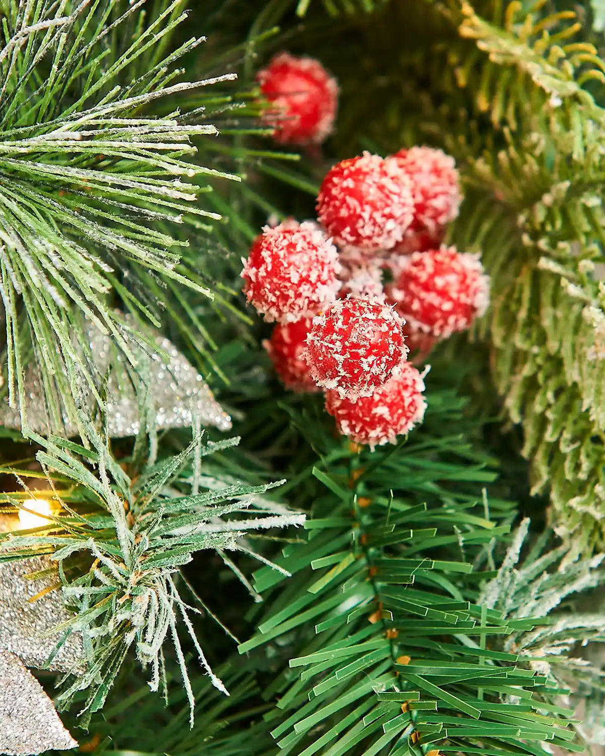 Close up of Christmas wreath with red frosted berries and green leaves