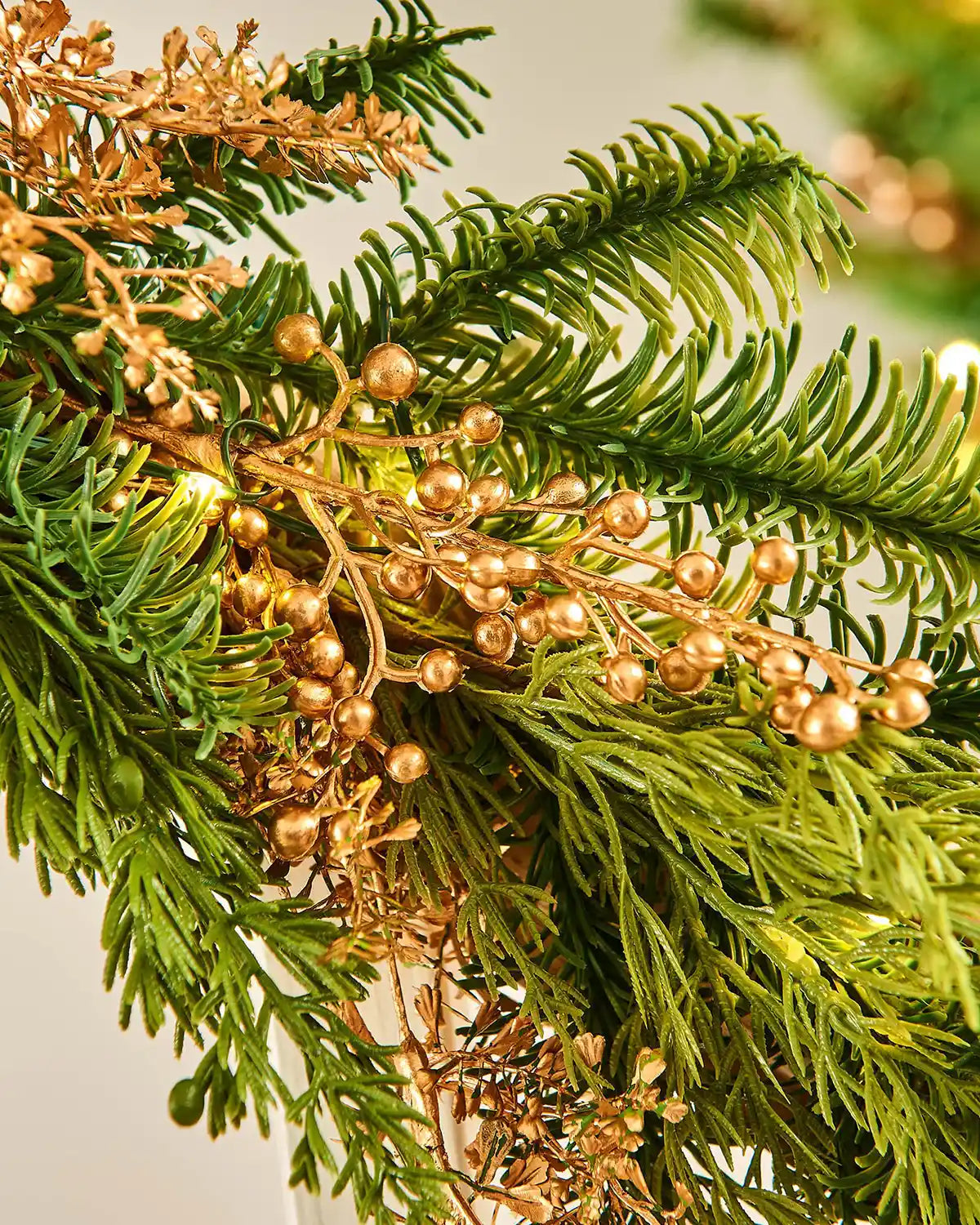 Close up of Gold berries with warm white lights on a staircase banister