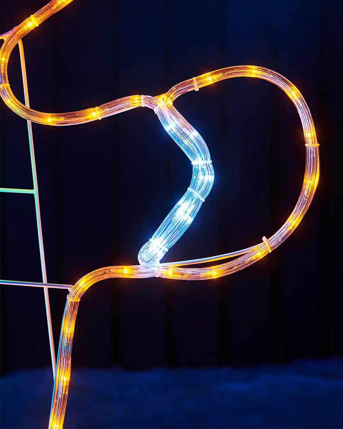 Close up of LED Gingerbread mans hand against dark background