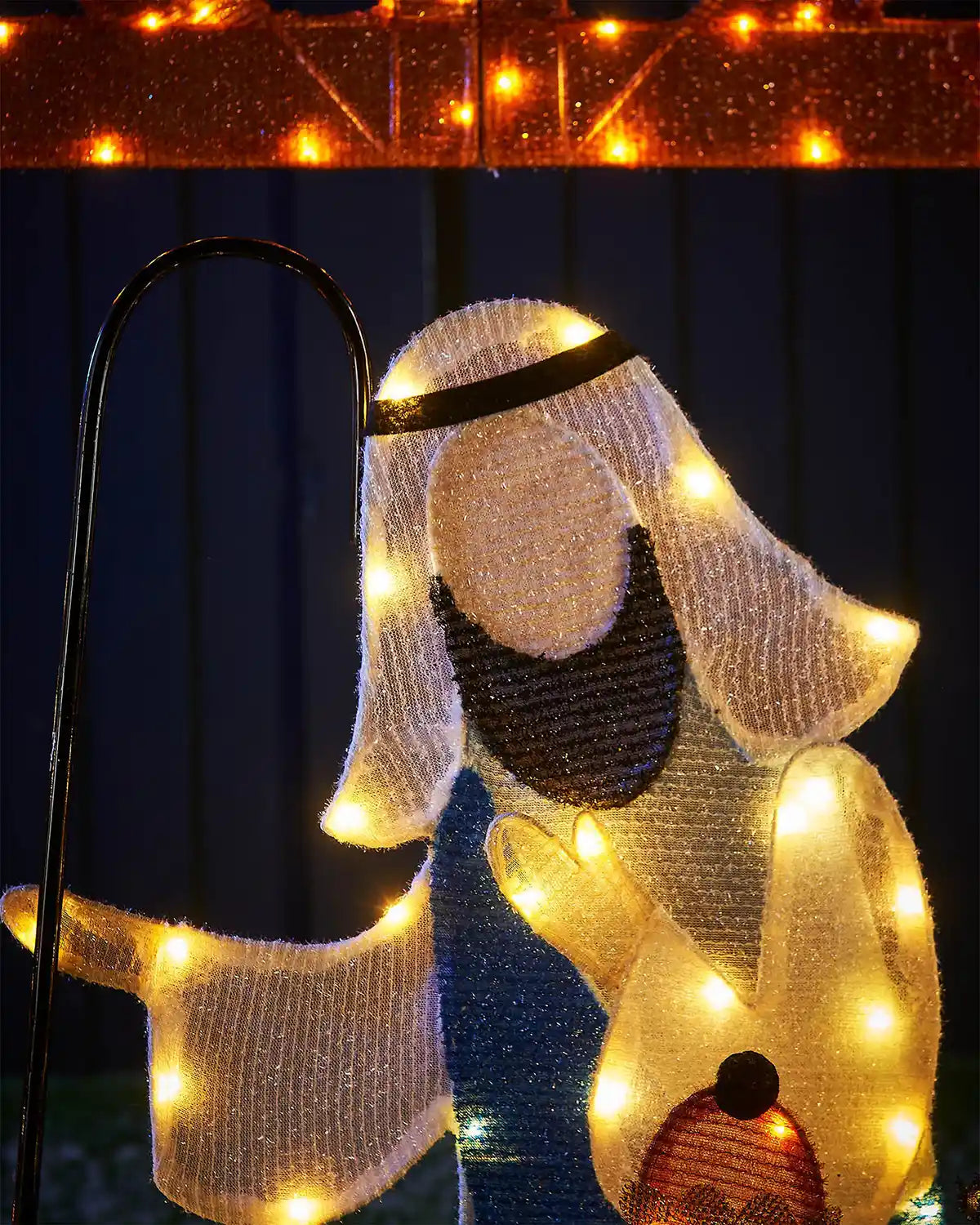 Close up of LED Joseph holding a walking staff on a dark background