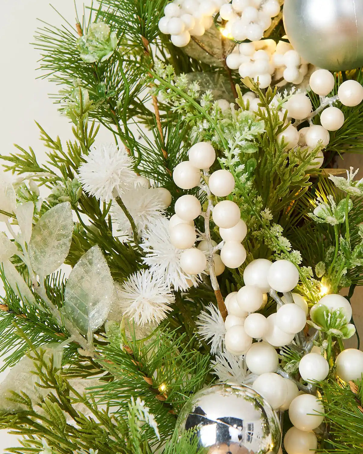 Close up of White berries, snowflakes and silver baubles on a Decorative Christmas wreath