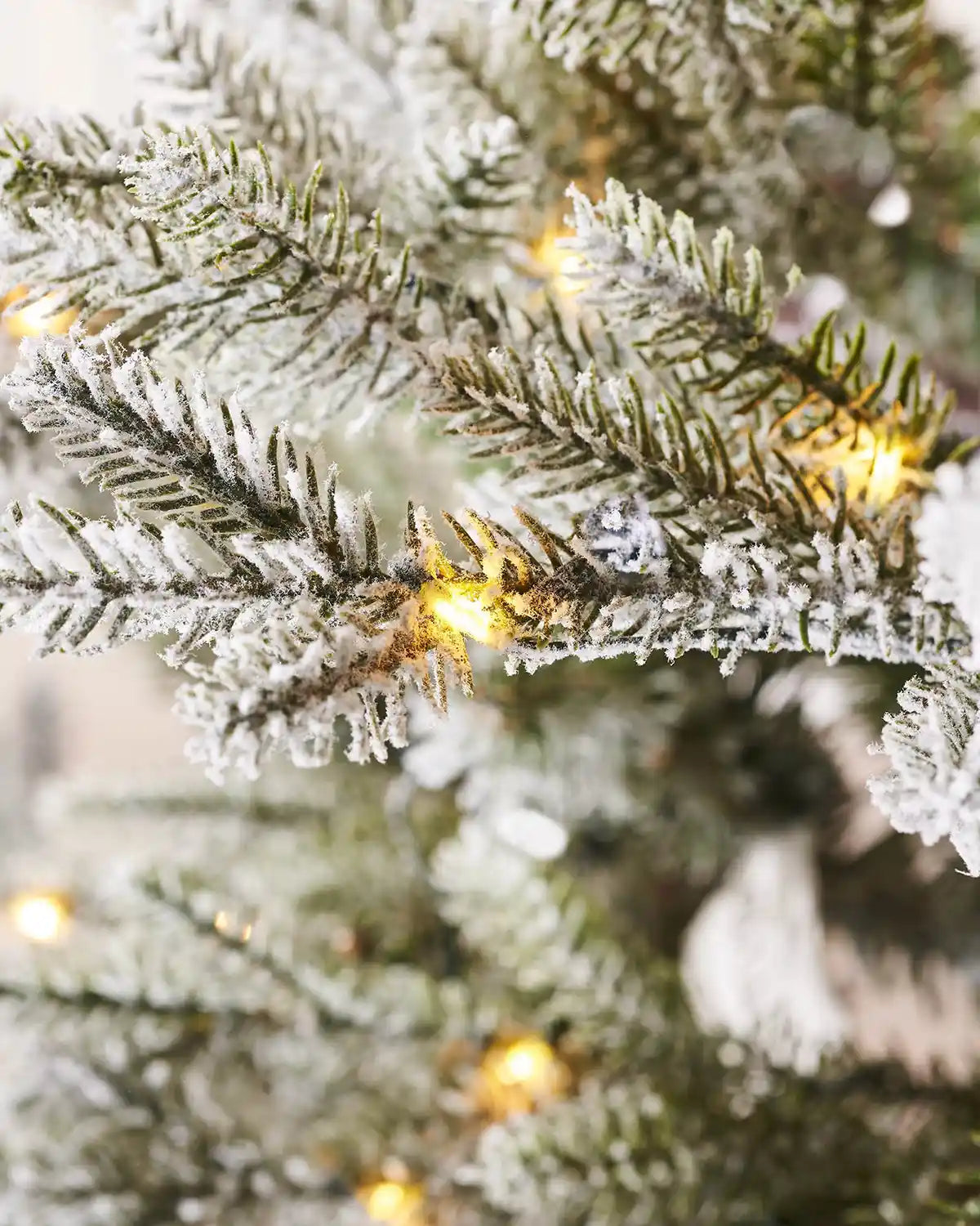 Close up of a 9ft Snow Flocked Douglas Fir's PVC and PE tips  Christmas Tree with lights 

