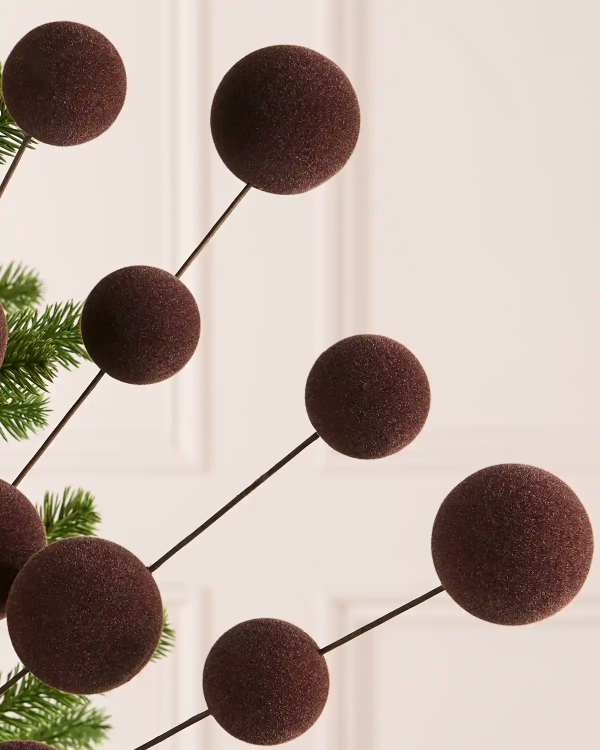 Close up of an Espresso velvet bauble pick on thin black stems against a light background