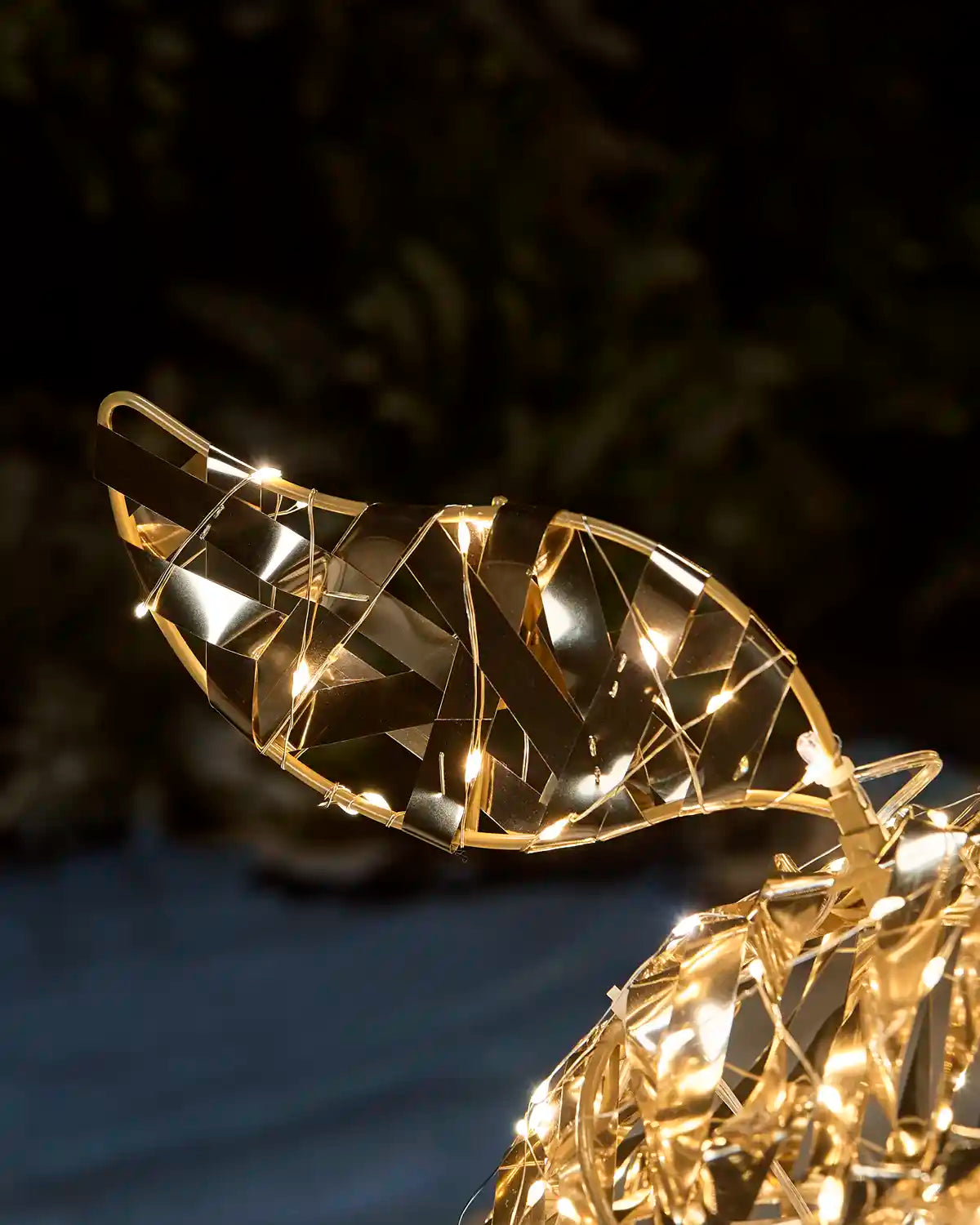 Close up of an LED does tail with warm white and Gold features against a snowy garden setting