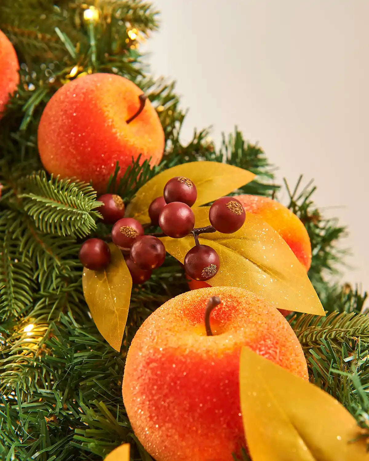 Close up of artificial oranges and peaches on a staircase banister against a Cream background