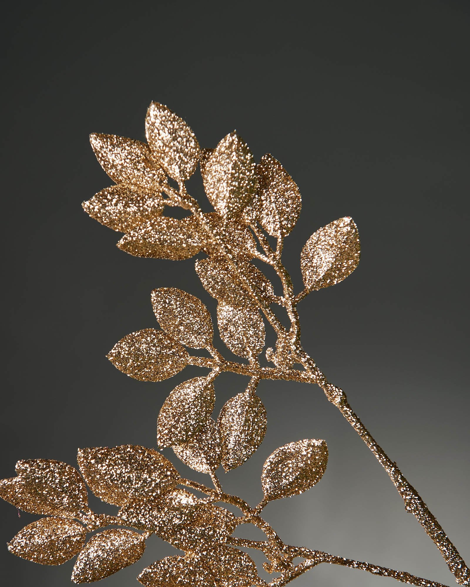 Close up of  glitter Gold leaf branch on a grey background