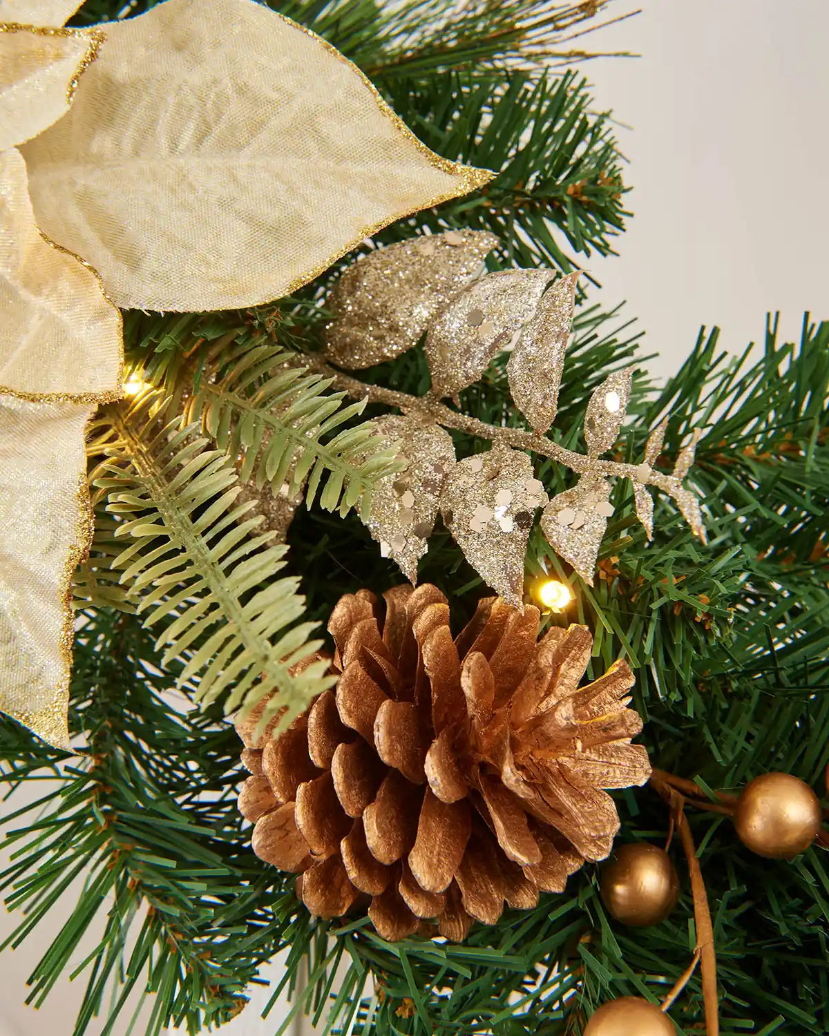 Close-up image of green garden with gold foliage highlighting sequined leaves and natural pinecone detail