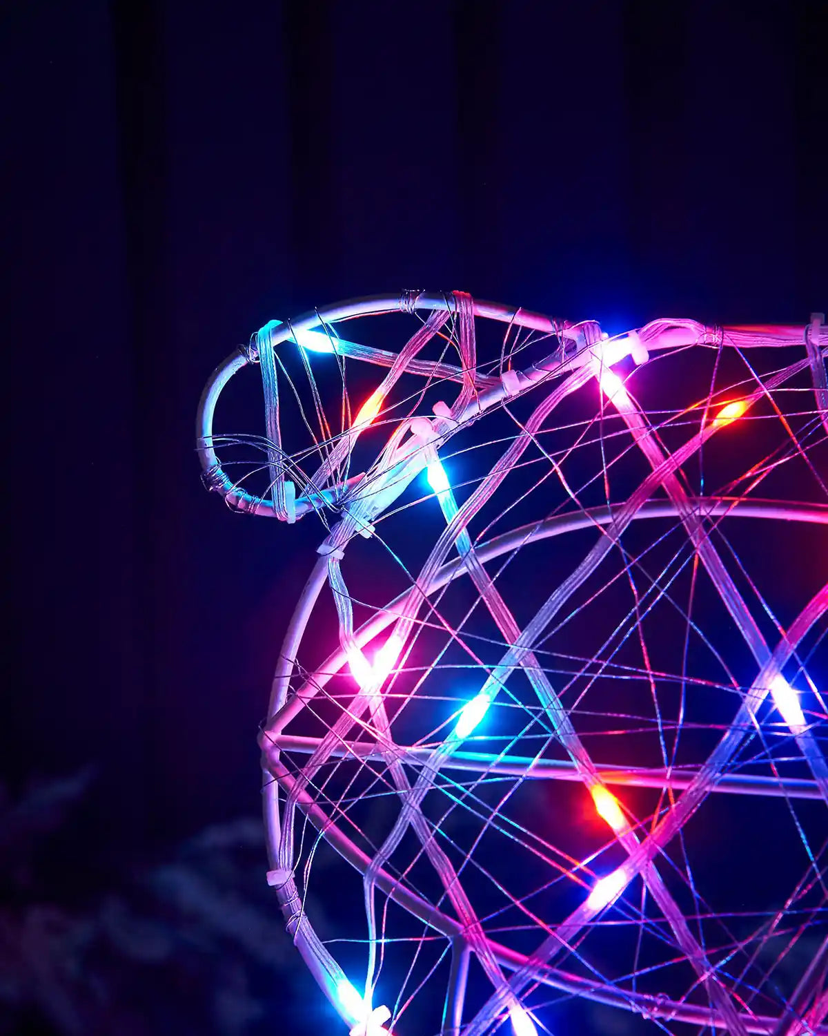 Close up of tail on a Decorative deer sculpture with colourful Aroura lights against a dark background