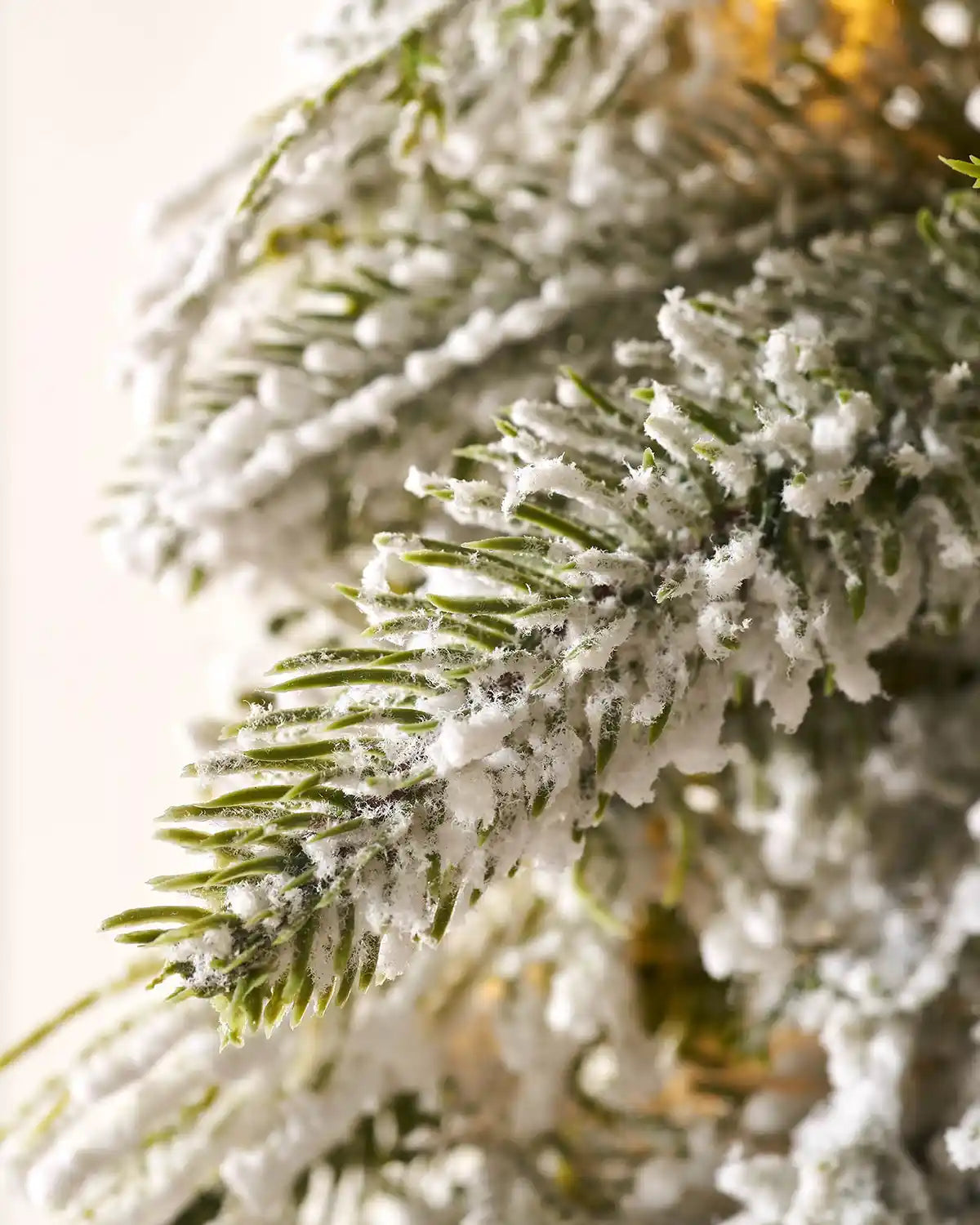 Close up of the PE tips of Pre-Lit Snow Flocked Natural Fir Majestic Wreath, 1.5 m on panel textured background