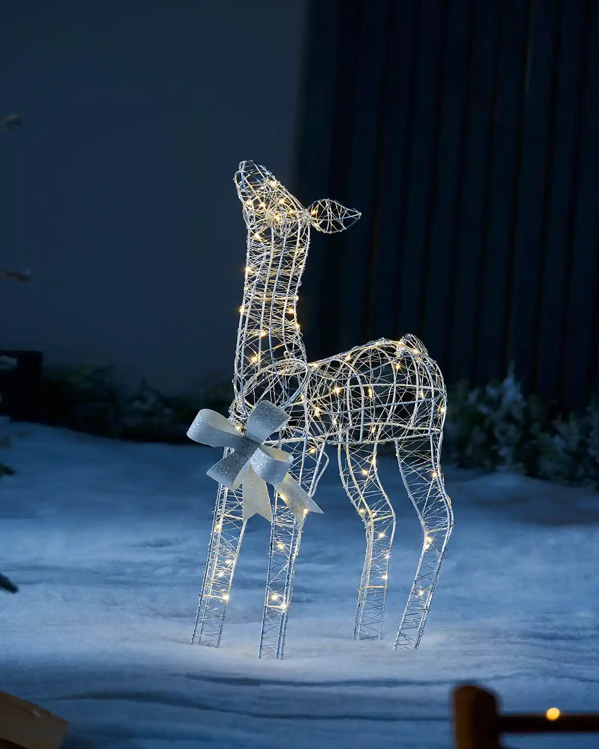 Close up of the calf in a snowy garden at night time