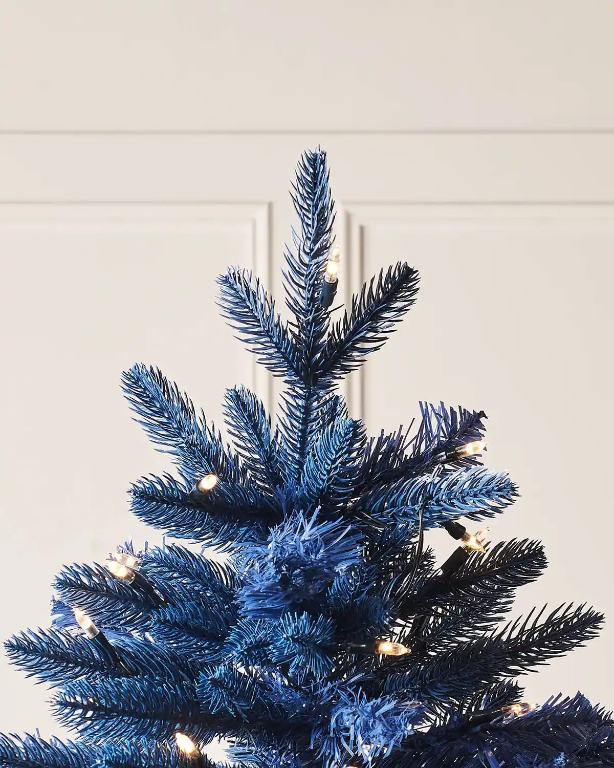 Close up of the top pf a Sapphire Blue Christmas tree with lights 