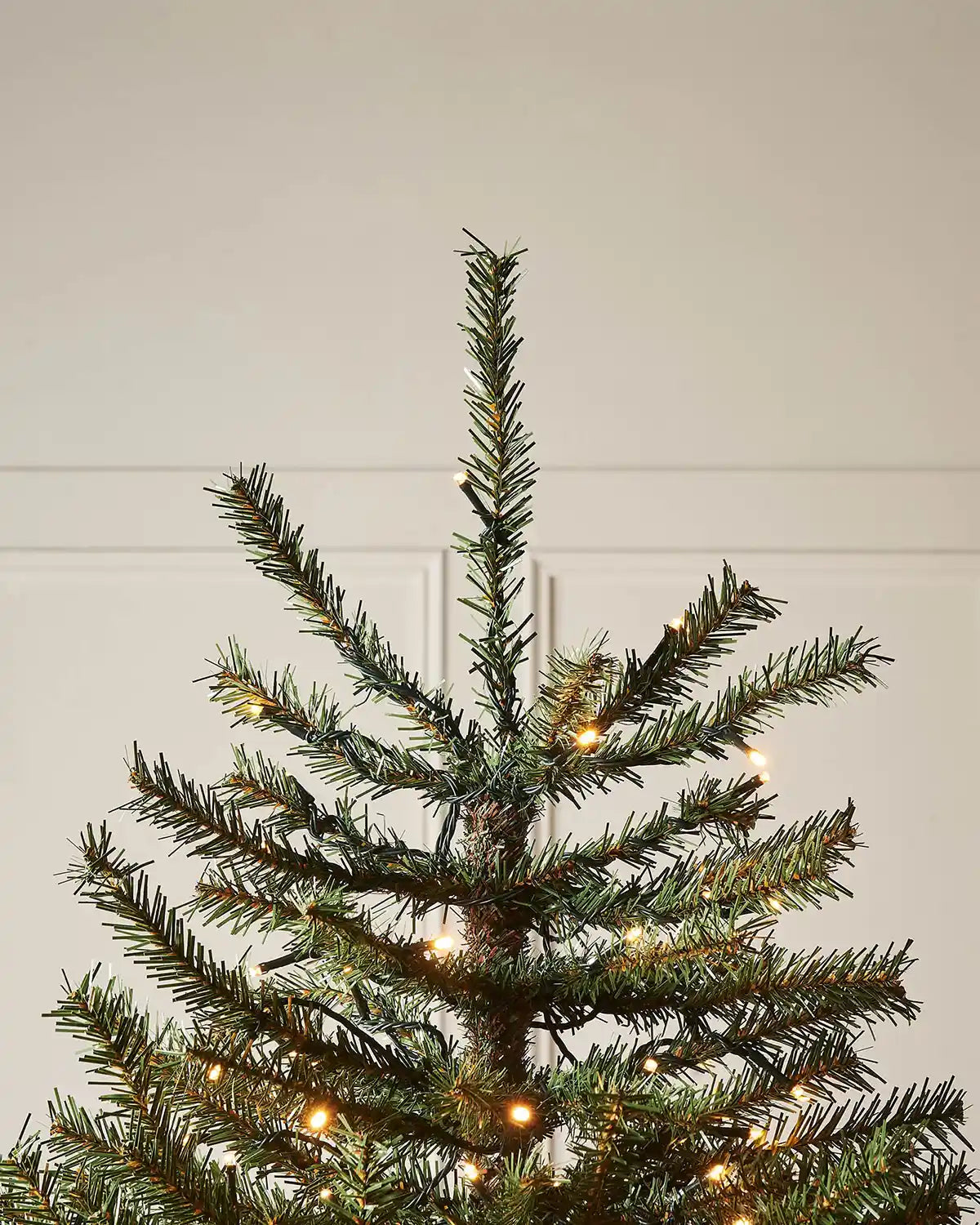 Close up of top of 7f Christmas tree with warm white lights 