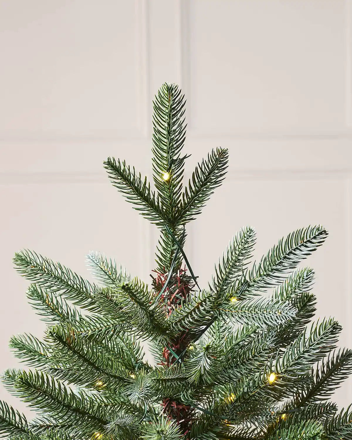 Close up of top of tree with PVC and PE tips against a cream panel wall