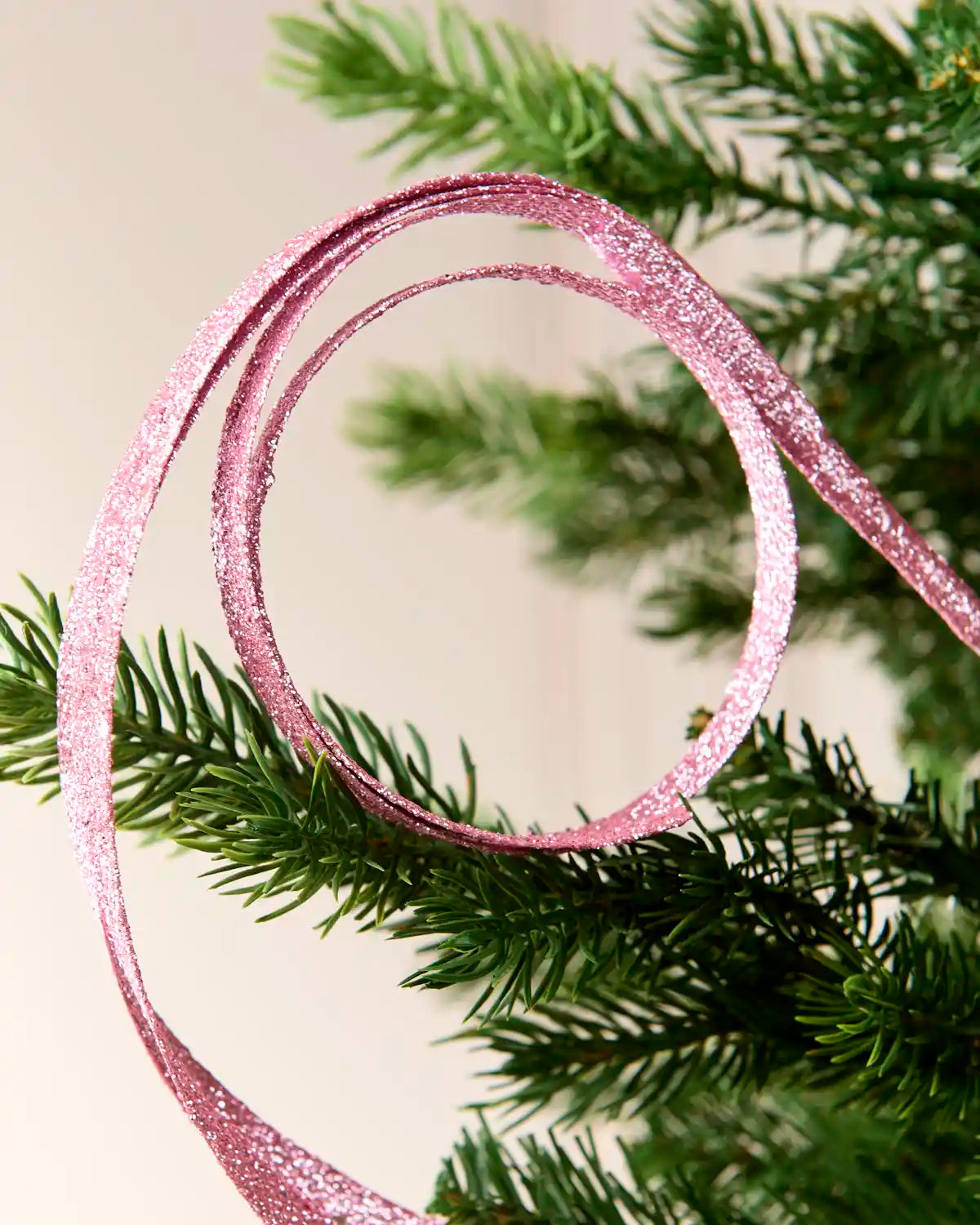 Close up pink Glitter Spiral Swirl Pick with green and cream blurred background
