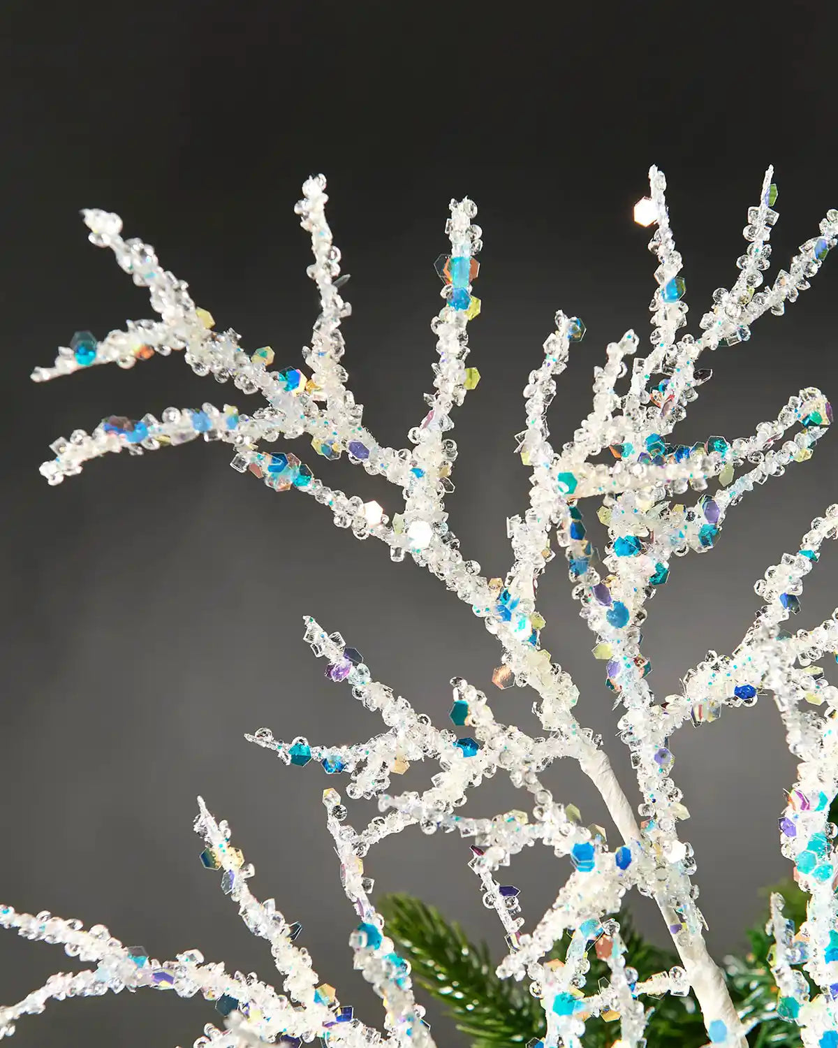 Close-up of white beaded crystal spray in front of grey wall background highlighting sequin details